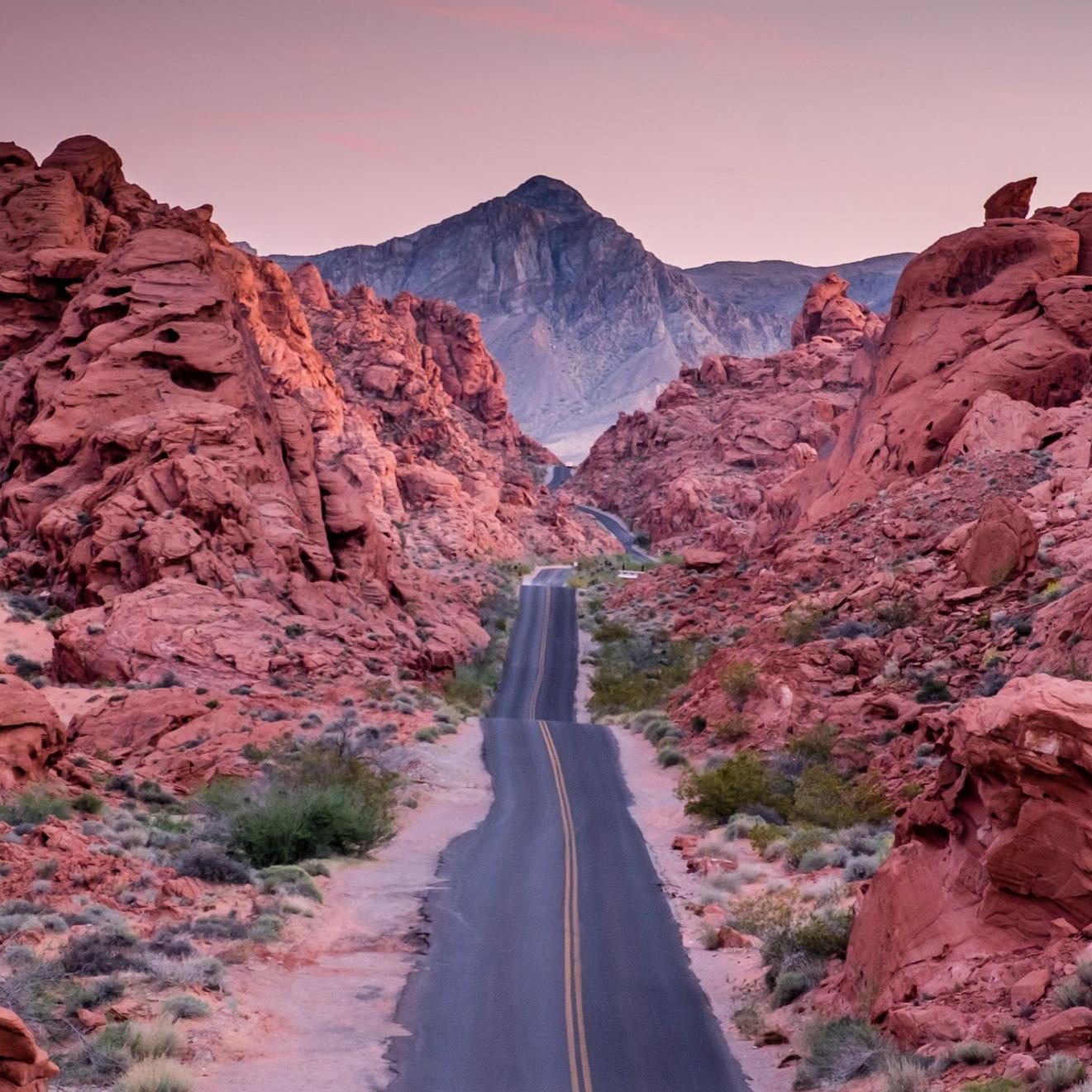 photo of empty road between rock formations